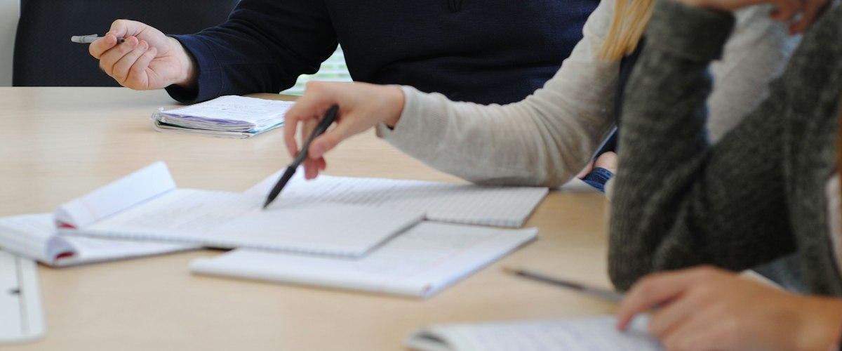 Colleagues working through notes and documents together at a table.